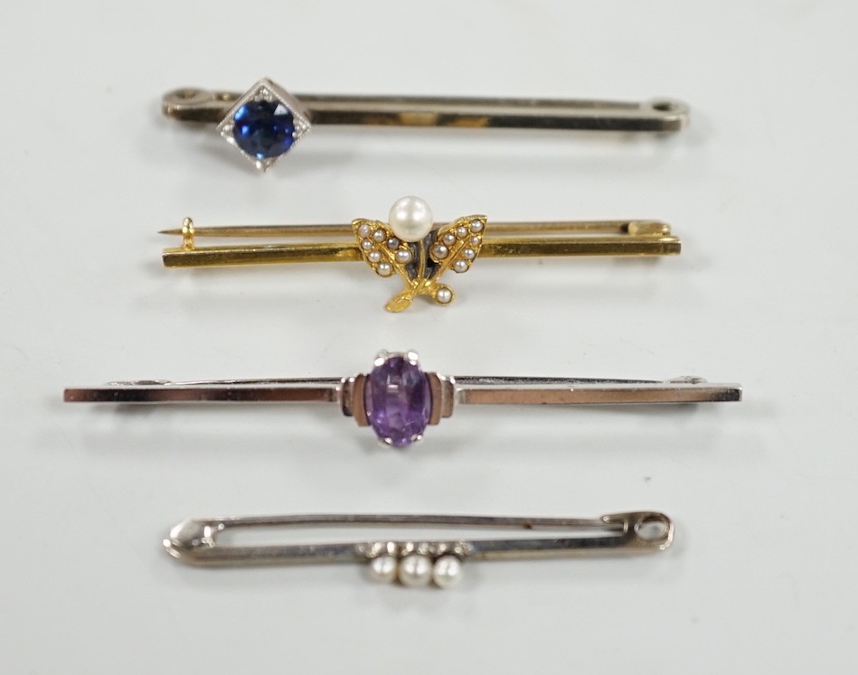 A 9ct white gold and synthetic? sapphire set bar brooch, 45mm and three other bar brooches including yellow metal and seed pearl, white metal and seed pearl and a 9ct and amethyst bar brooch, gross weight 8.1 grams.